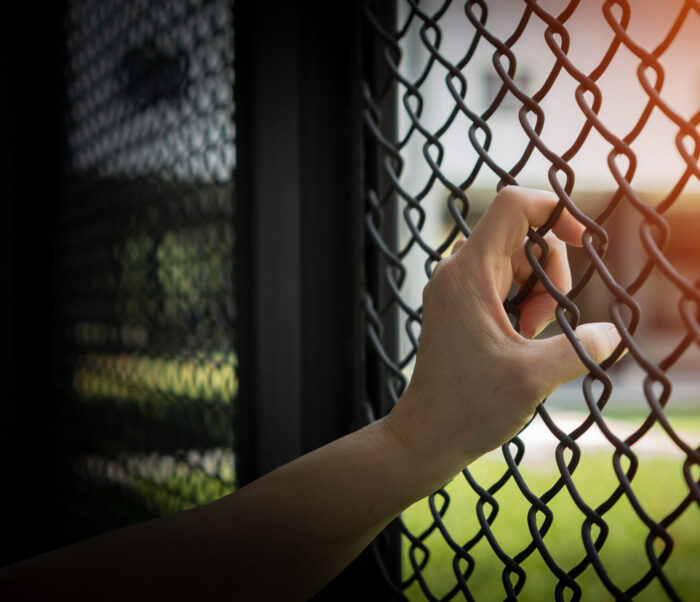 Slavery Trade And Human Trafficking Victim Concept With Woman Prisoner Slave In Jail Being Tortured Or Abused In Violation With Hand Holding Cage Wire Mesh For International Day For Remembrance Of Slave Trade And Abolition